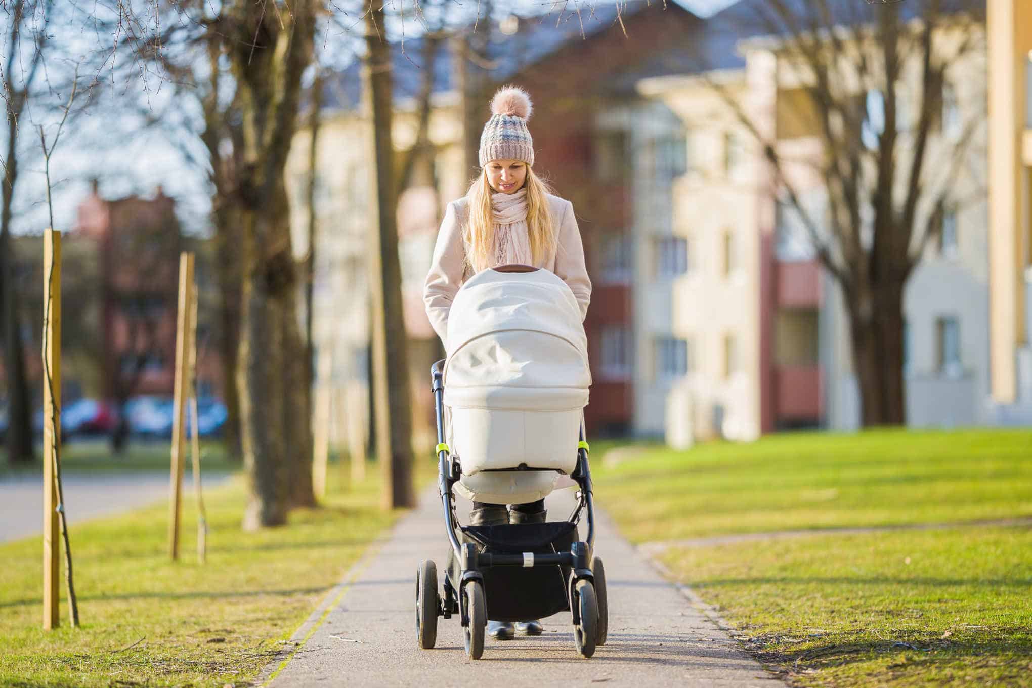 Henkilö työntämässä lastenvaunuja.