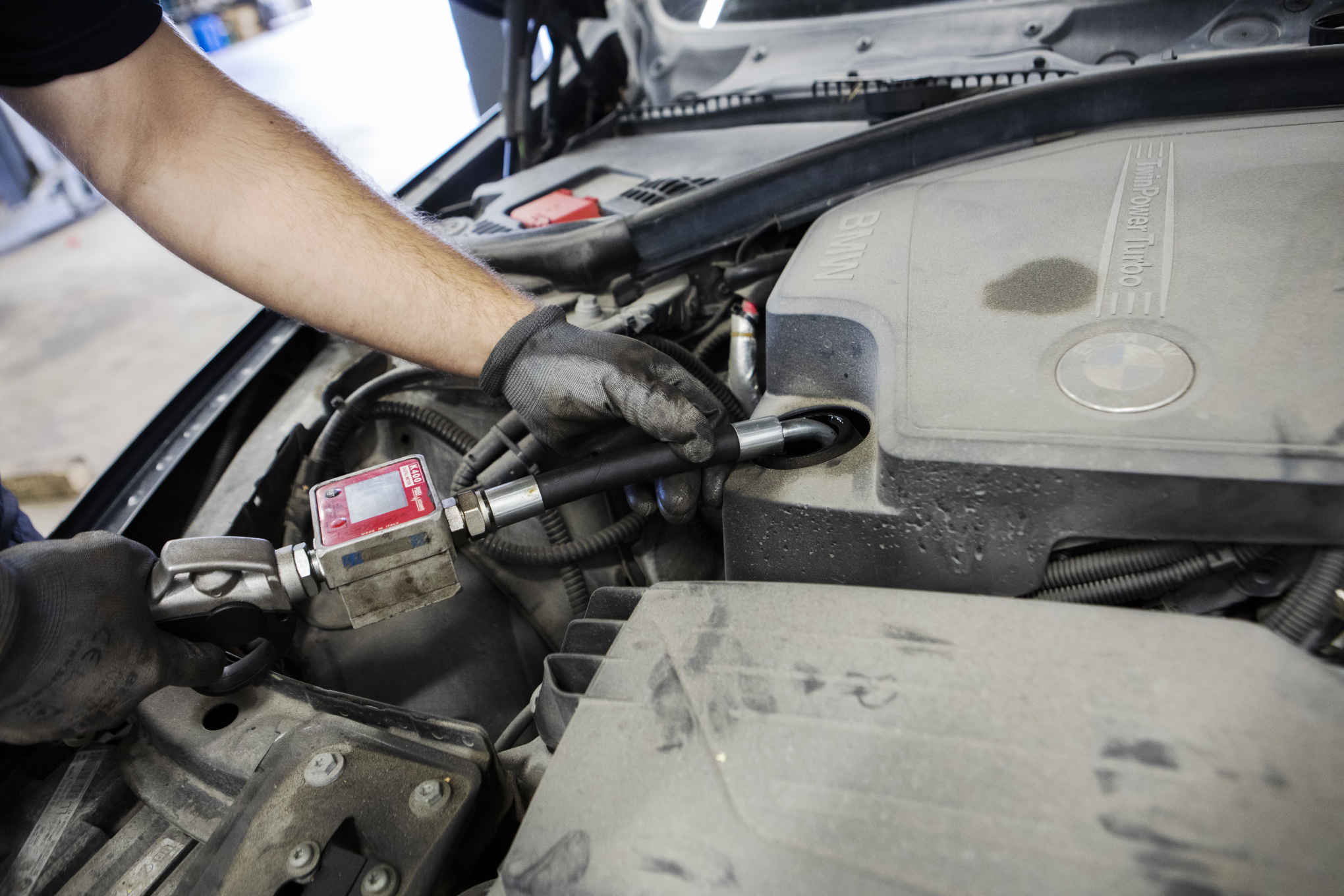 Henkilö korjaamassa auton moottoria.