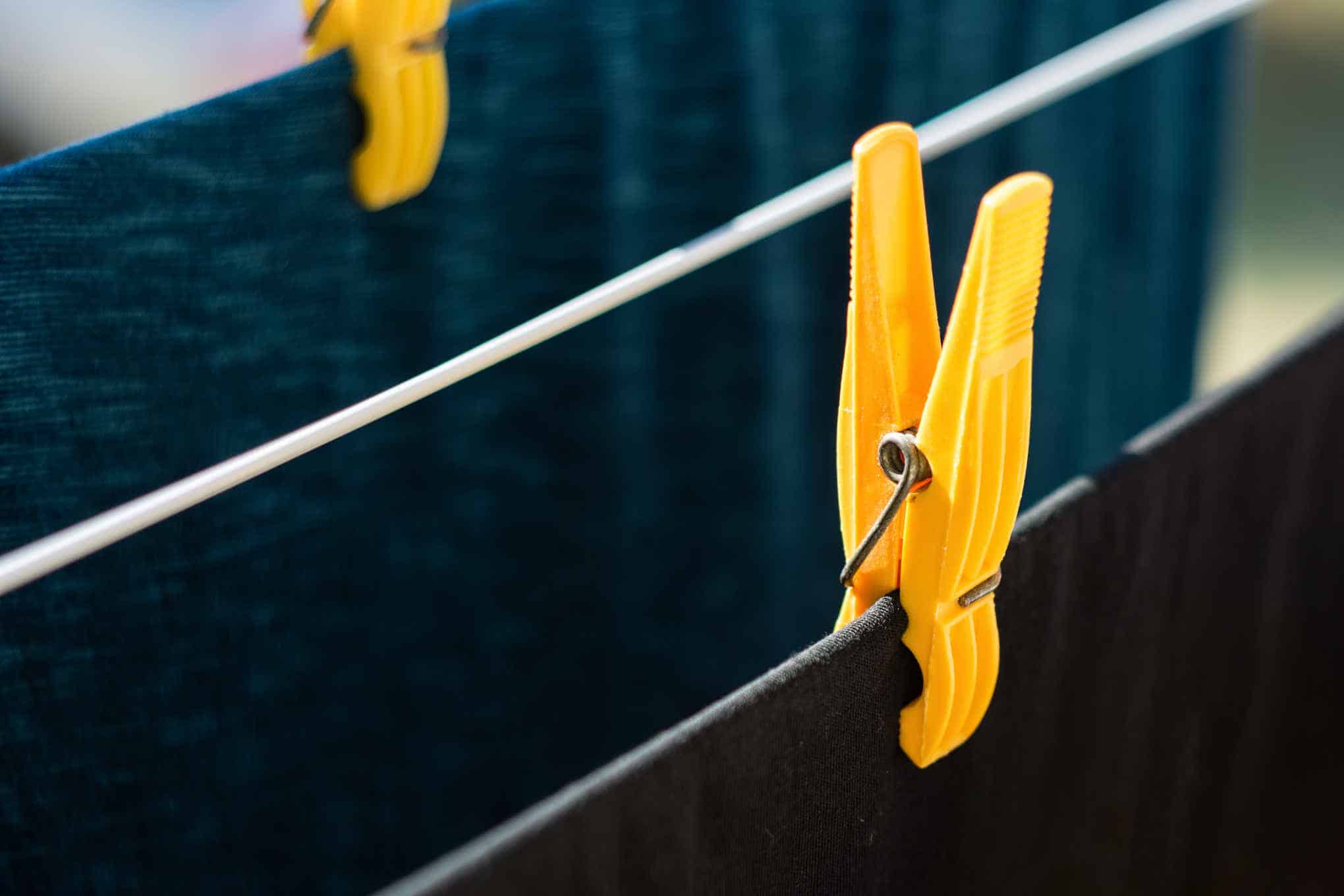 Pyykkipojilla kiinnitettyjä vaatteita pyykkinarulla.