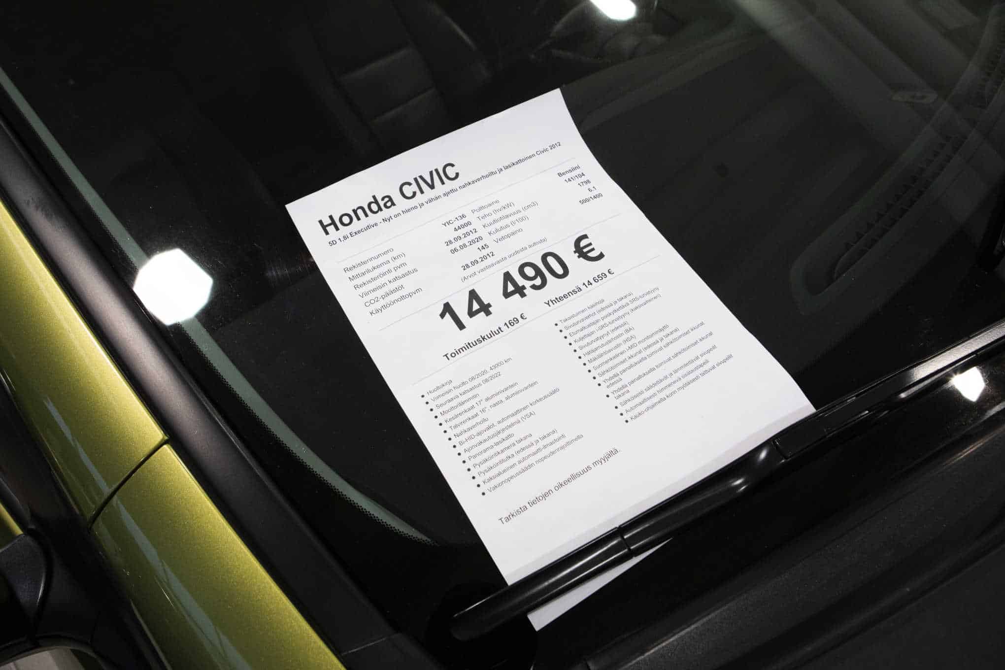 Honda-merkkisen auton hintalappu, joka on kiinni auton tuulilasissa.