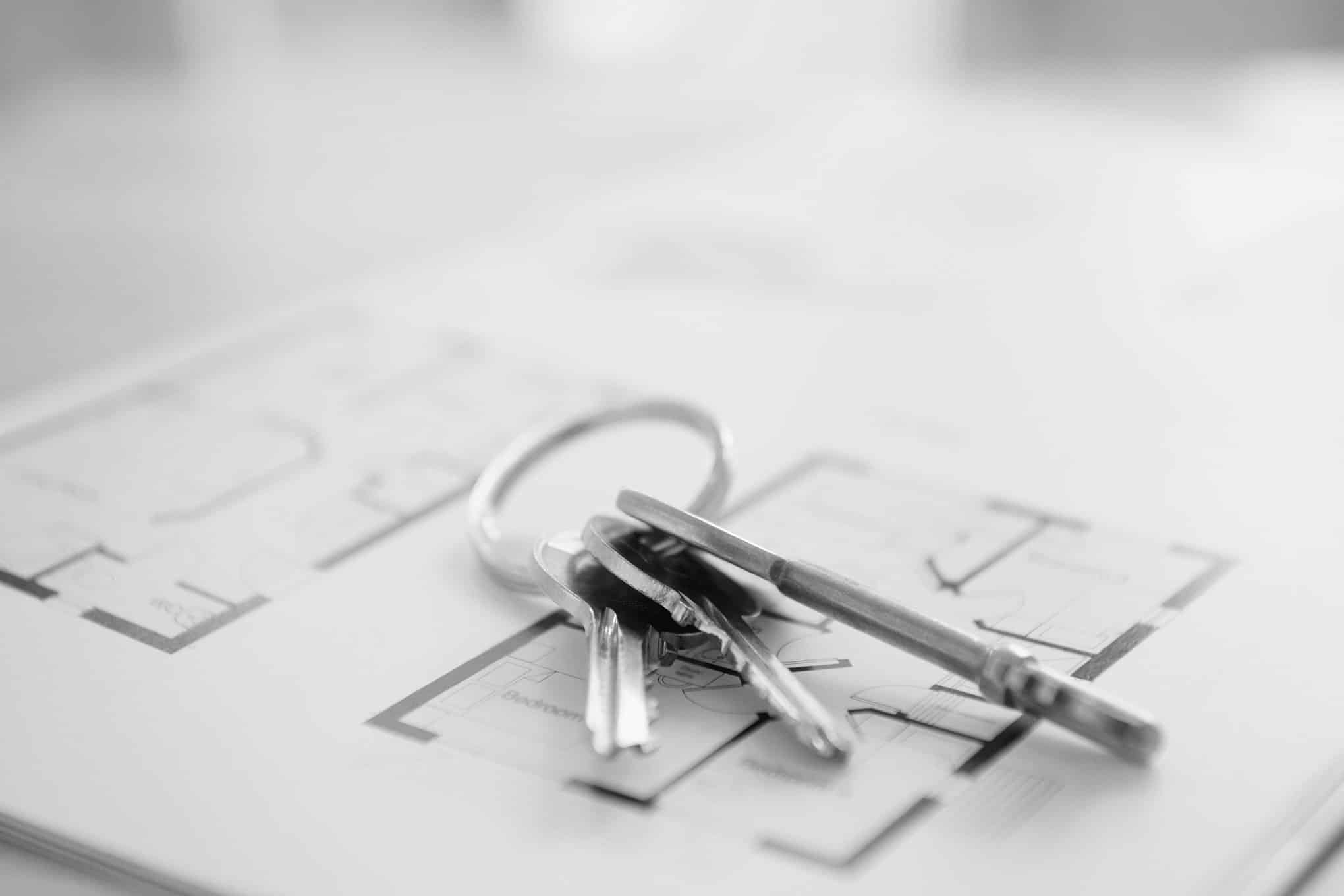 Avaimet pohjapiirustus-paperin päällä.