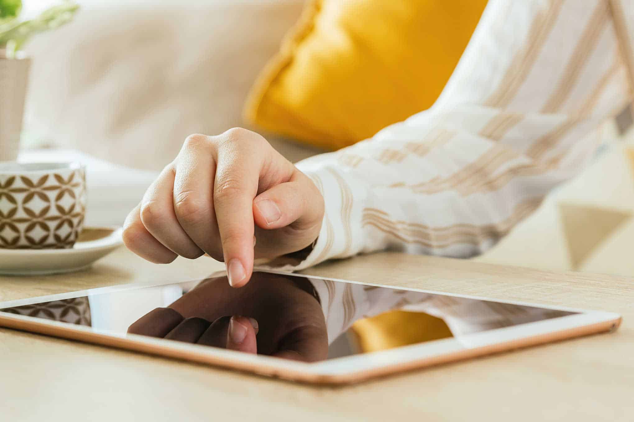 Henkilö koskettaa tabletin näyttöä.