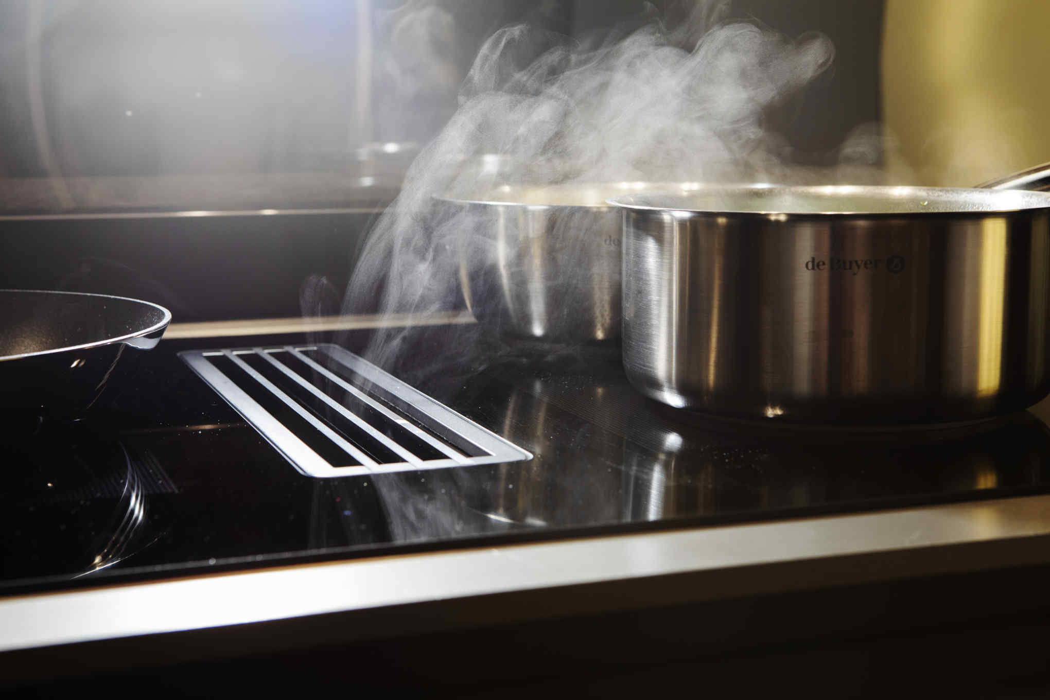 Induktiotaso liesituulettimella. Induktiotason päällä on kattila.