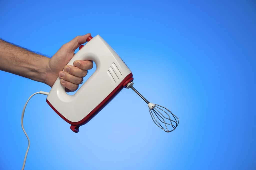 Henkilö pitää kädessään sähkövatkainta.