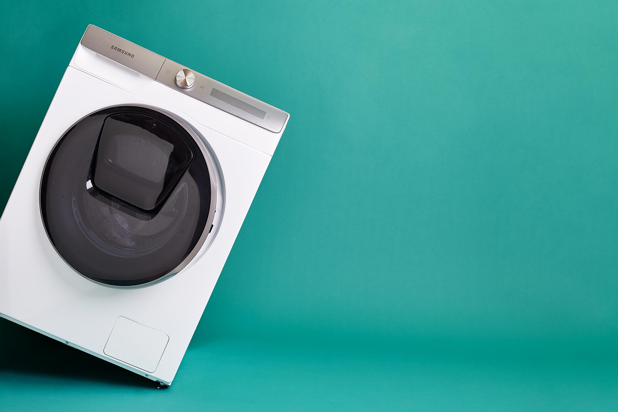 Kallellaan oleva pyykinpesukone.