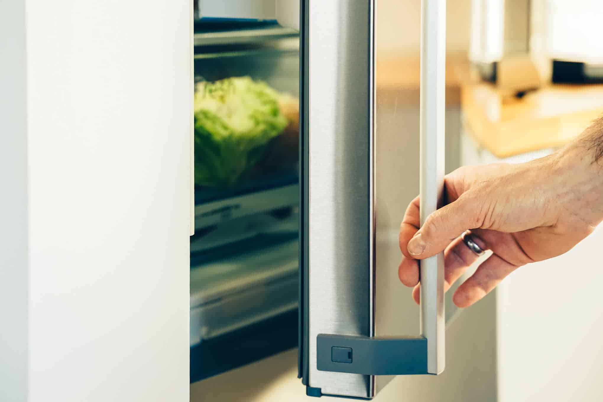 Henkilö avaamassa jääkaappipakastimen ovea.