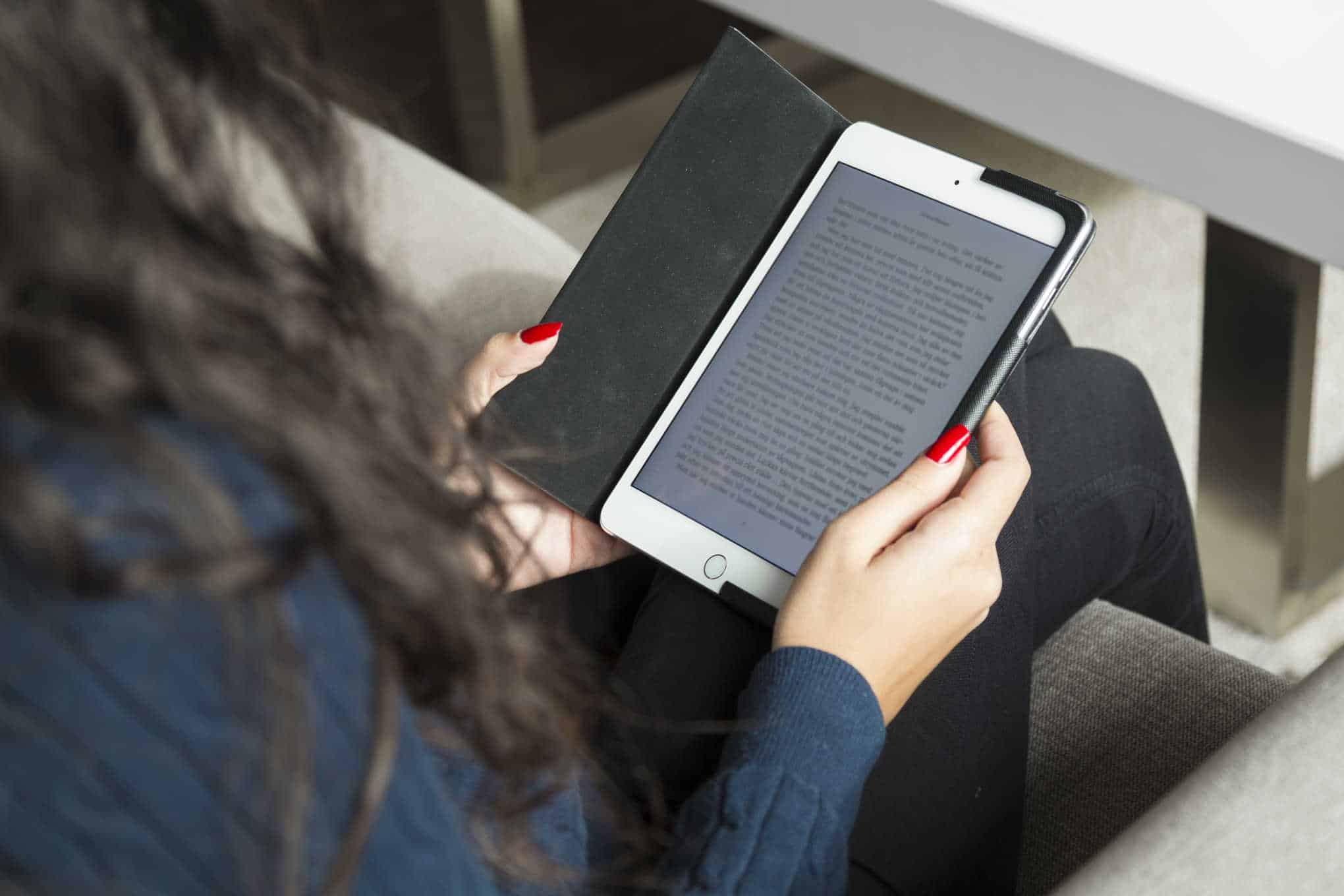 Henkilö lukee kirjaa sähköisellä lukulaitteella.