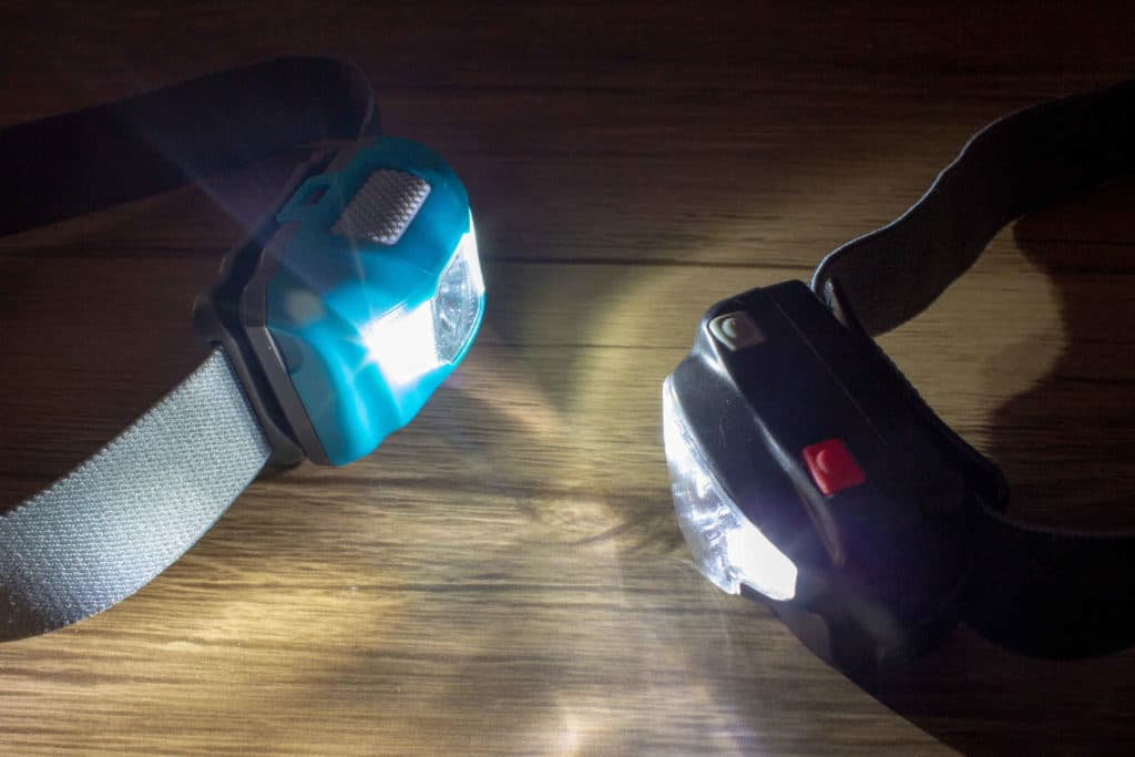 Kaksi otsalamppua, joissa palaa valo.