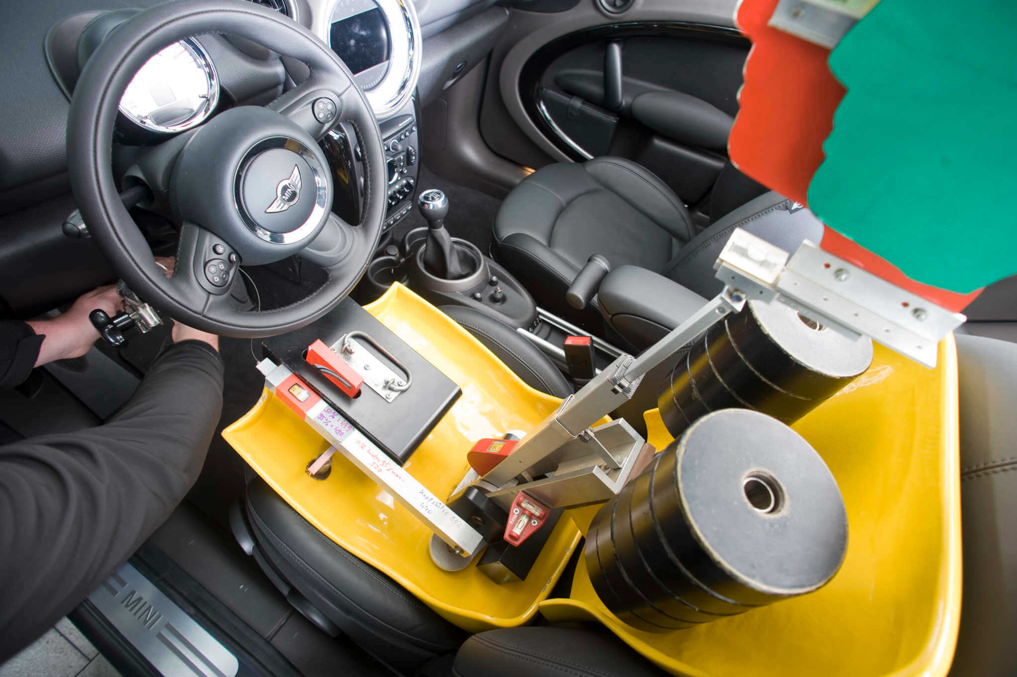 Henkilö mittaamassa auton matkustamon tiloja testinuken avulla.