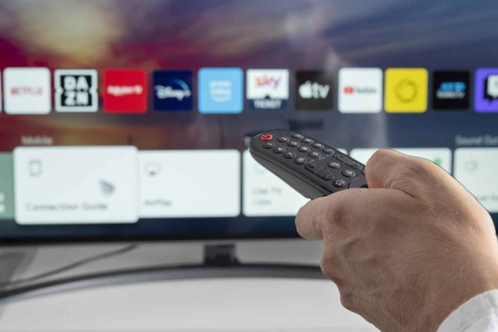 Henkilö käyttämässä televisiota kaukosäätimellä.