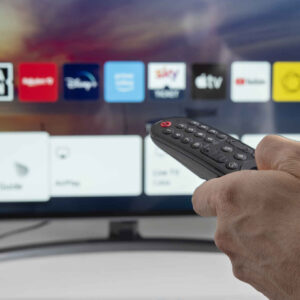 Henkilö käyttämässä televisiota kaukosäätimellä.