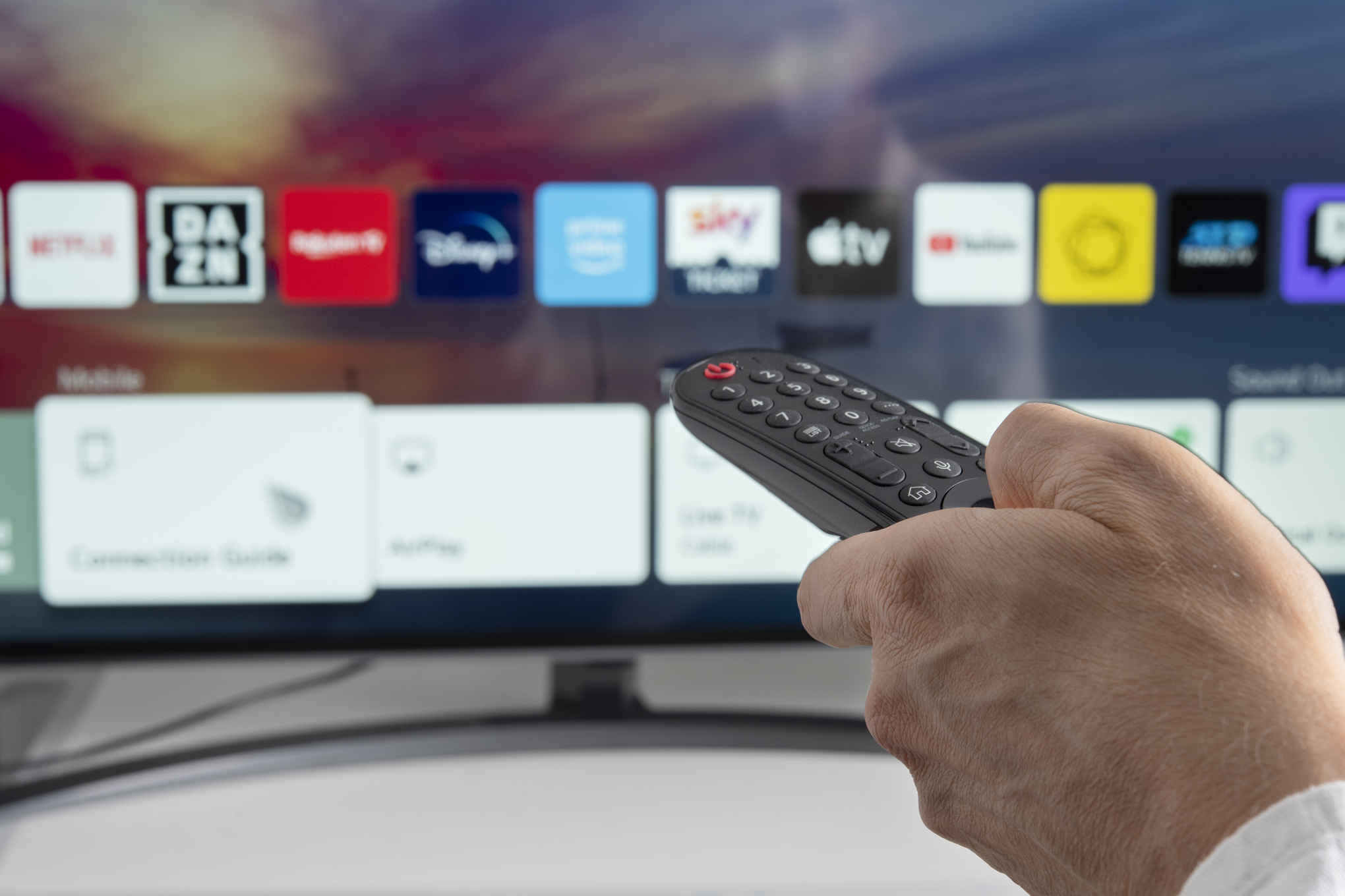 Henkilö käyttämässä televisiota kaukosäätimellä.