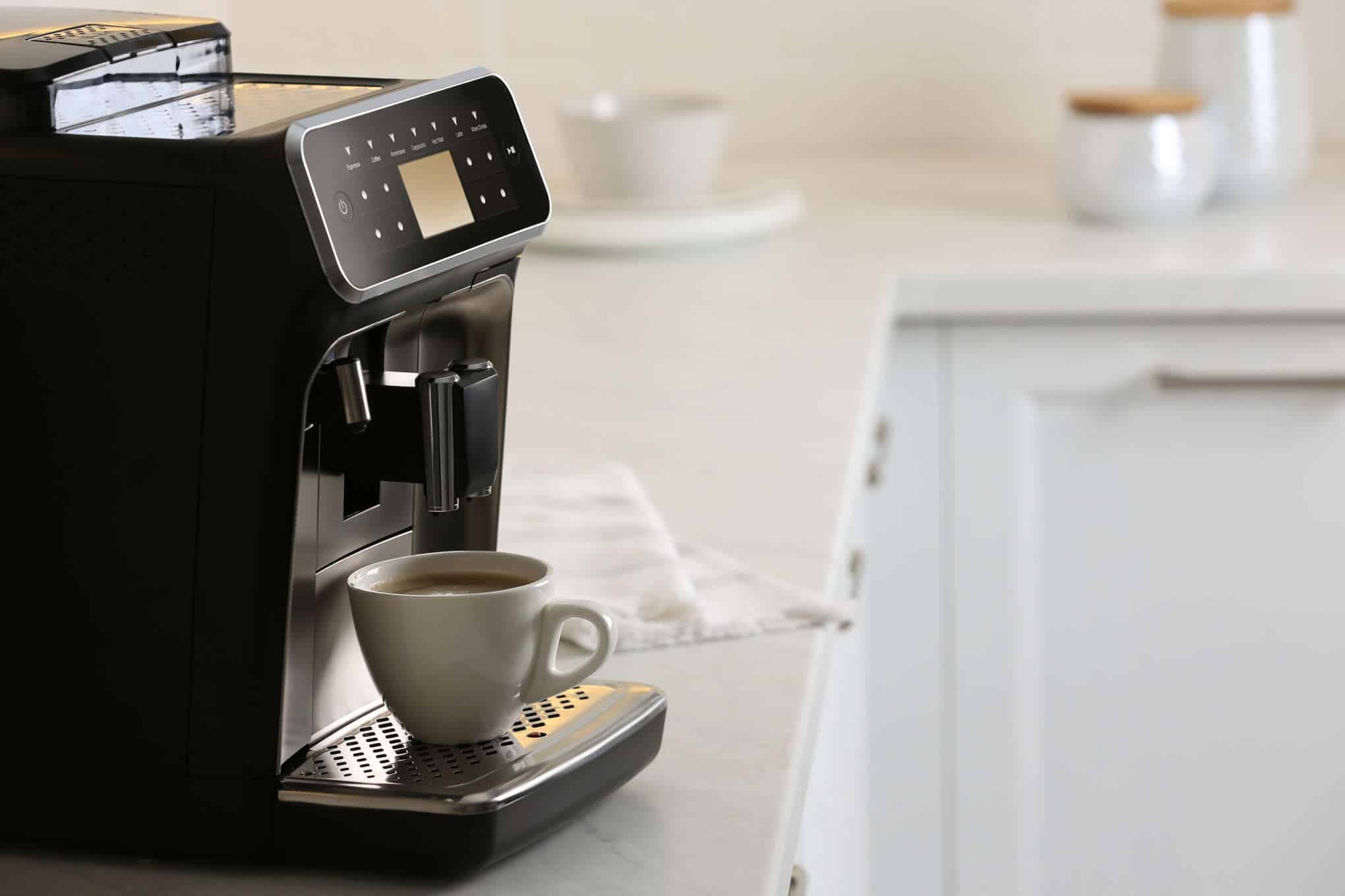 Musta kahvikone keittiötasolla.