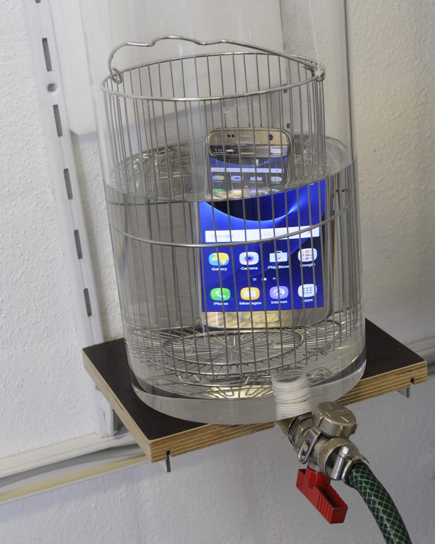 Älypuhelin upotettuna vesiastiaan.