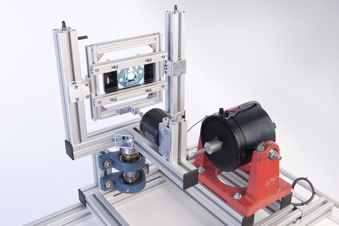 Älypuhelin ja tärisyttävä testauslaite.