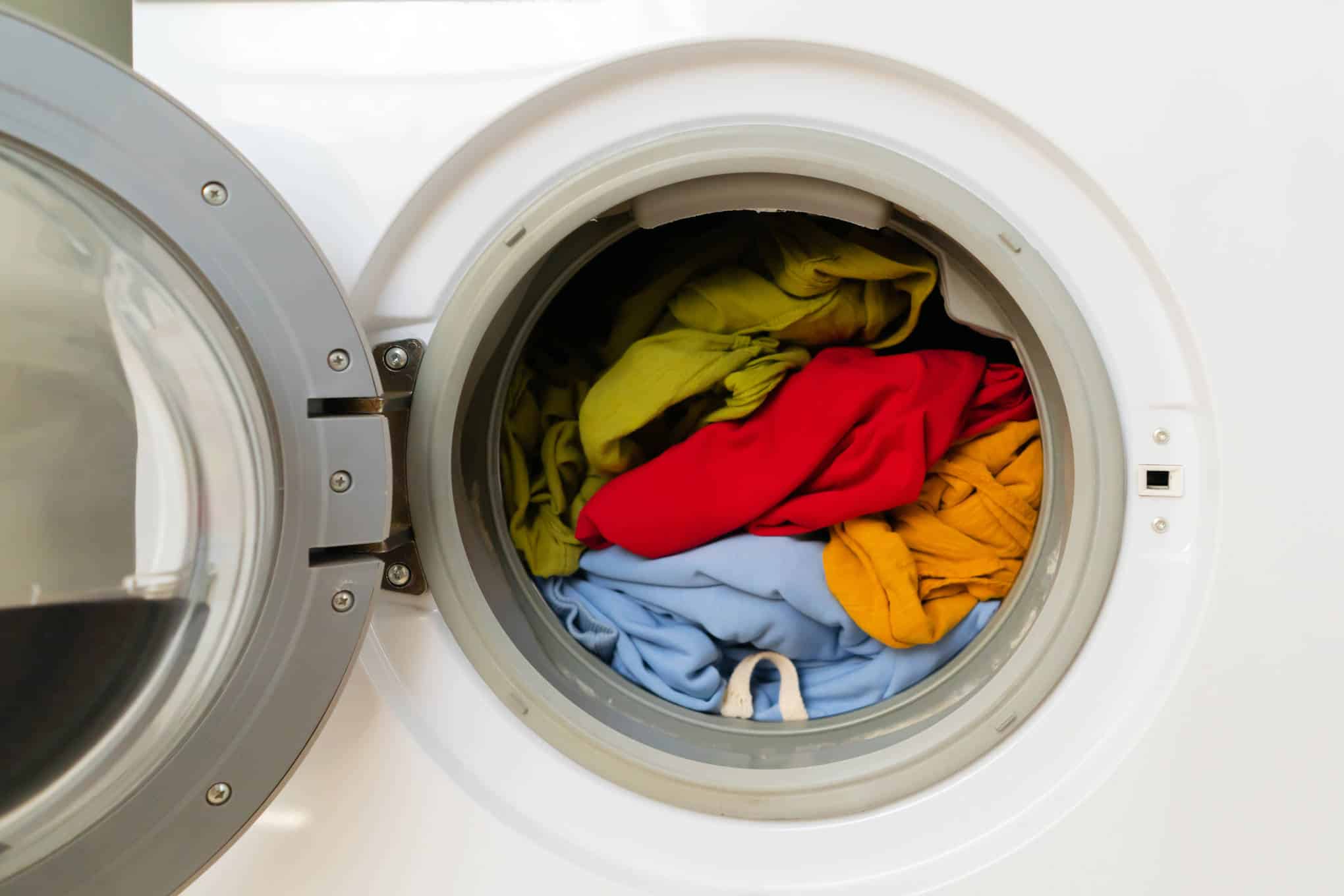 Pyykinpesukone, jonka sisällä on vaatteita.