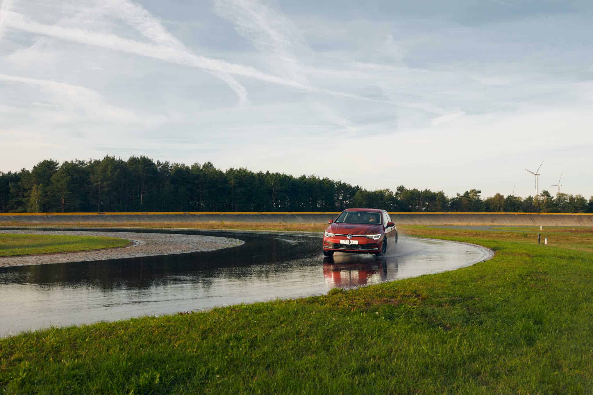 Auto ajamassa mutkaan märällä ajoradalla.