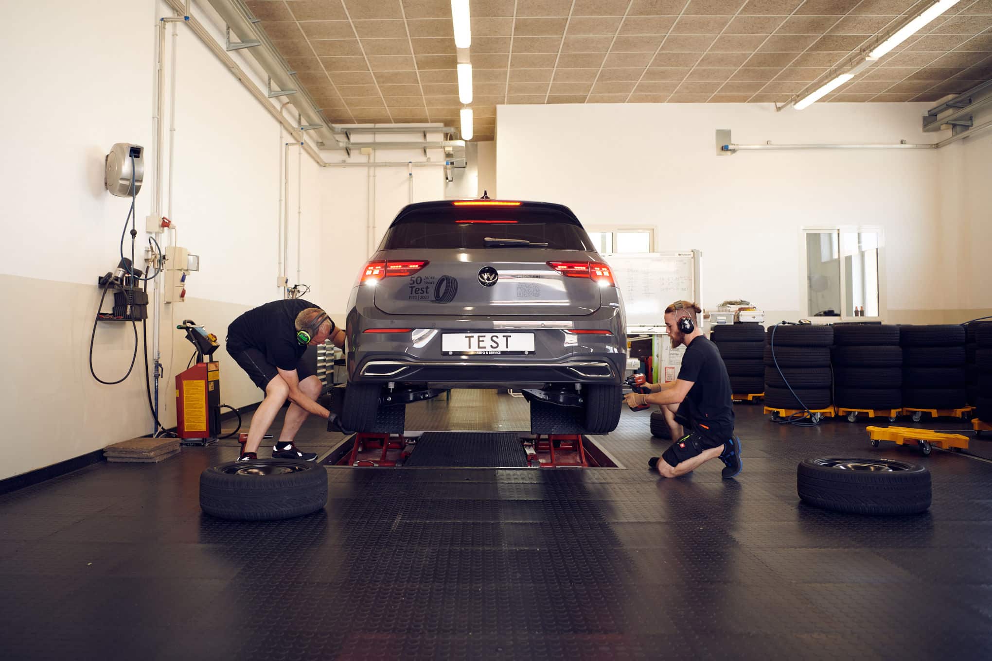 Kaksi henkilöä vaihtamassa auton renkaita.