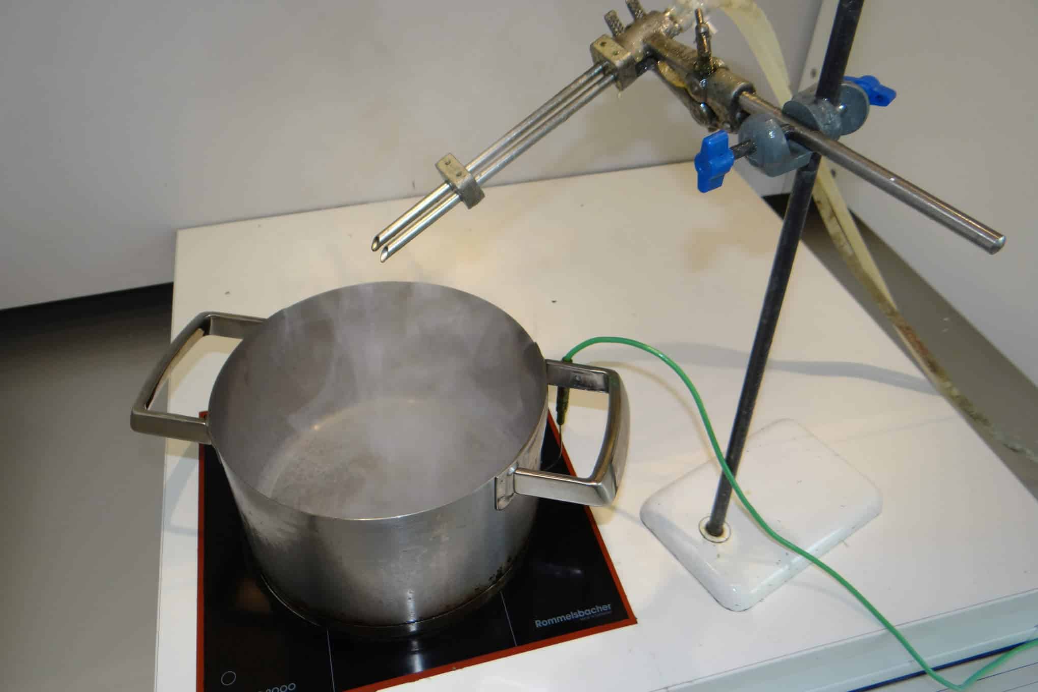 Testauslaitteistoa ja kattila, jolla kuumennetaan öljyä ja vettä.