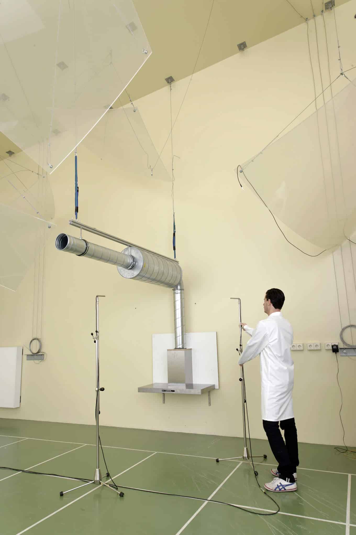 Testaaja, liesituuletin ja testauslaitteistoa laboratoriossa.