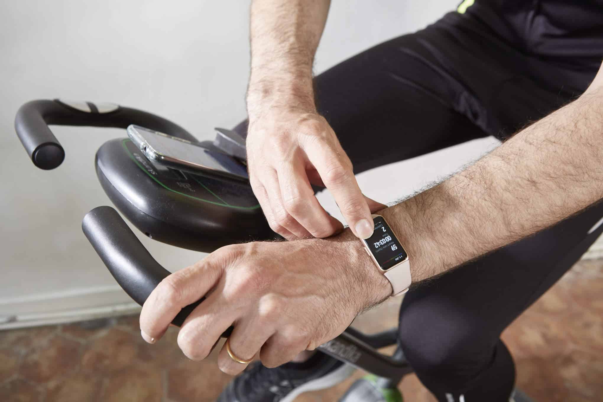 Aktiivisuusranneke käytössä kuntopyöräilevällä henkilöllä.