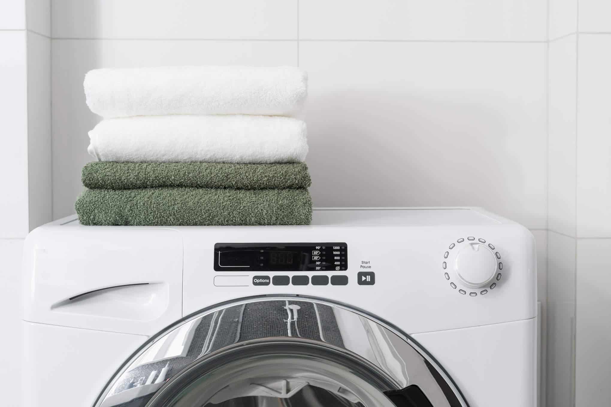 Kuivaava pesukone, jonka päällä on pyyhkeitä.