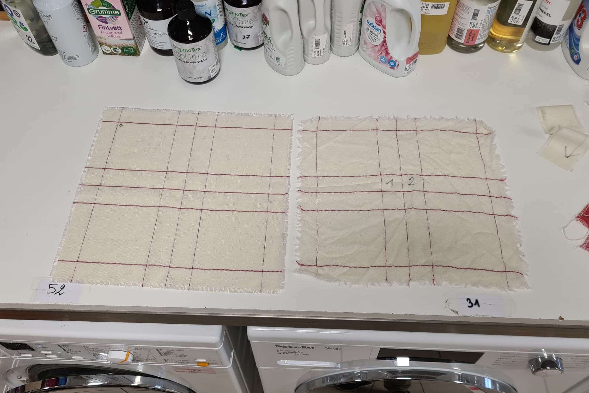 Kaksi ruudullista villakangasta sekä pesuainepulloja.