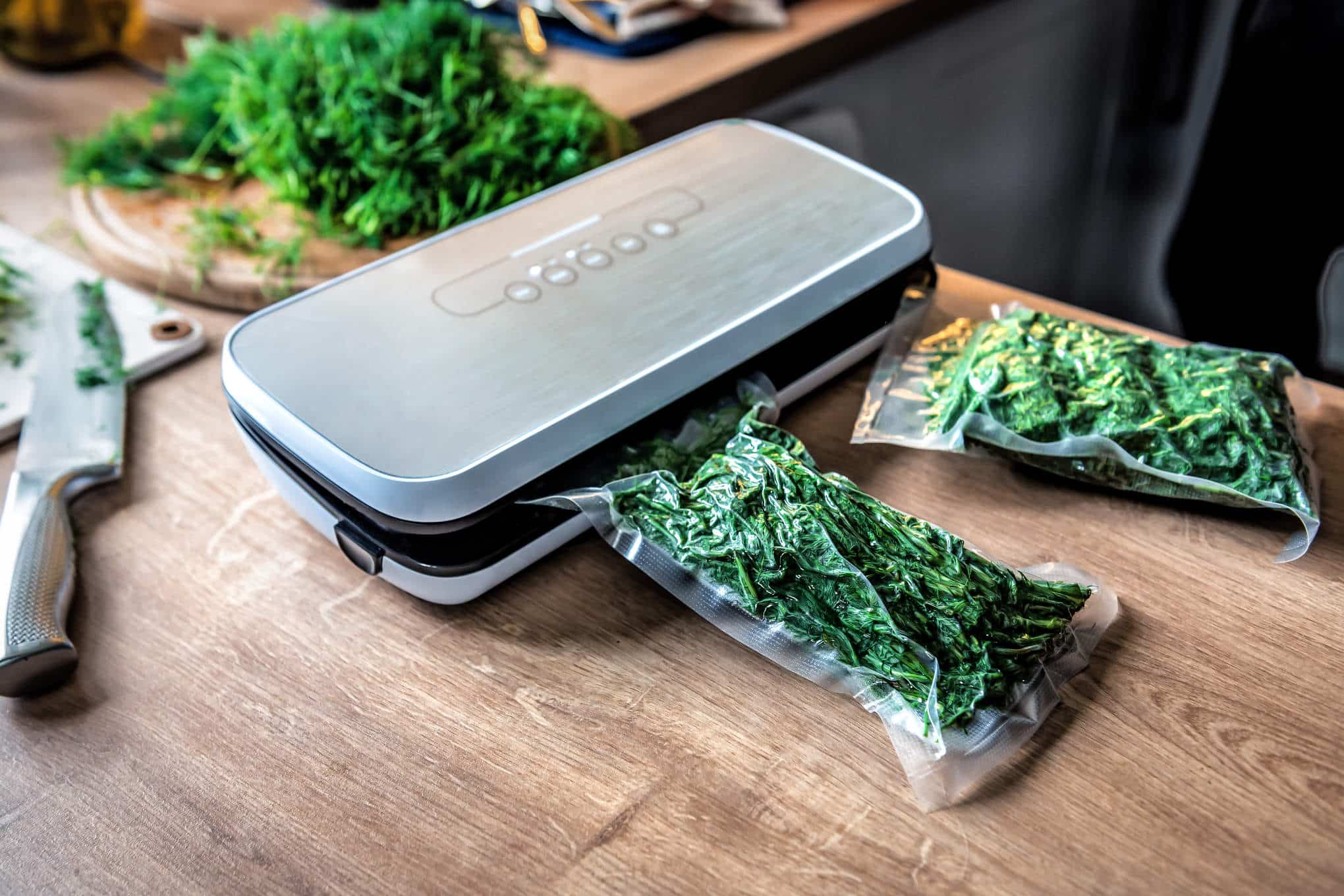 Tyhjiöpakkauslaite ja laitteella pakattuja yrttejä.