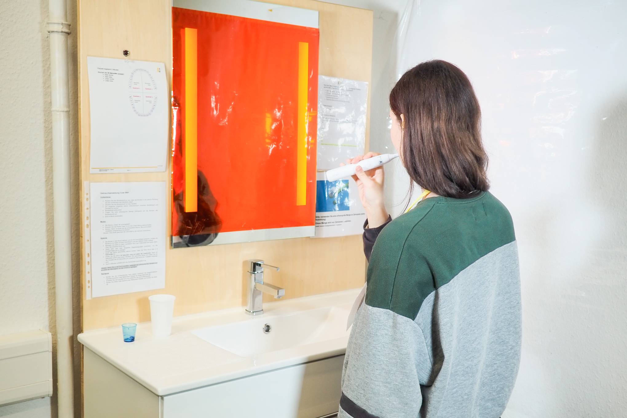 Henkilö harjaamassa hampaita testilaboratoriossa.