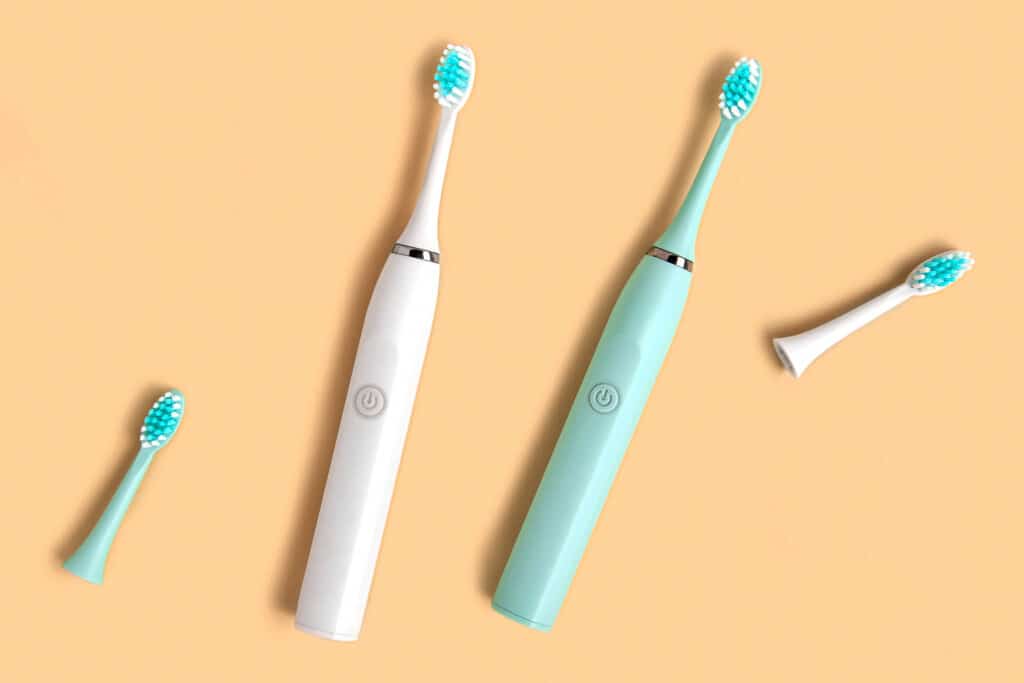 Valkoinen ja turkoosi sähköhammasharja.