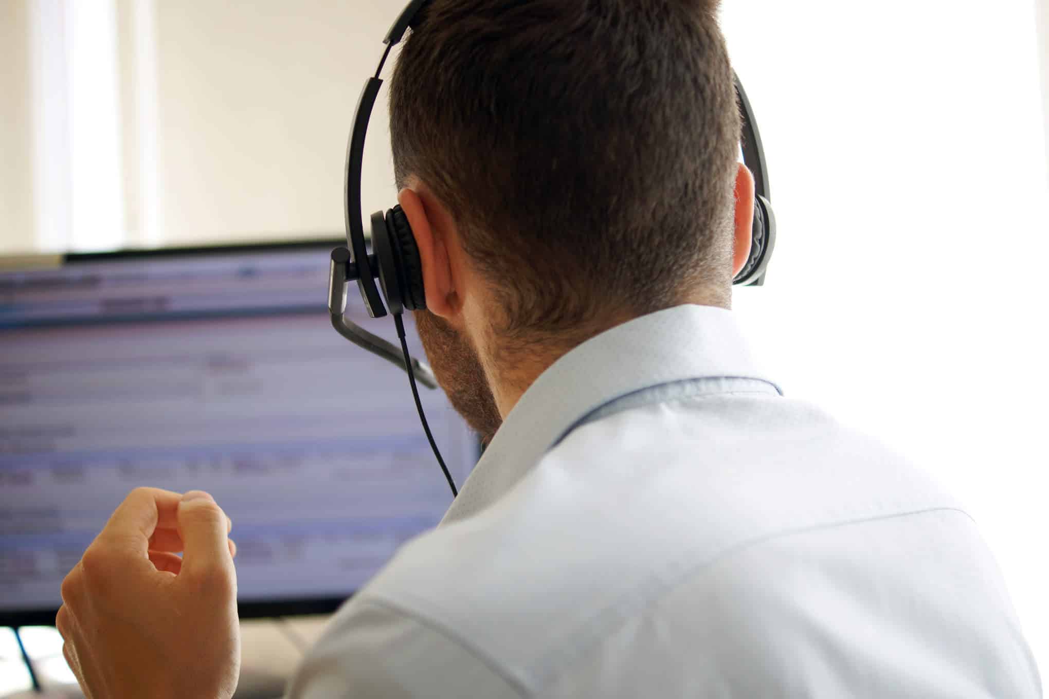 Asiakaspalvelija kuulokkeet päässä.