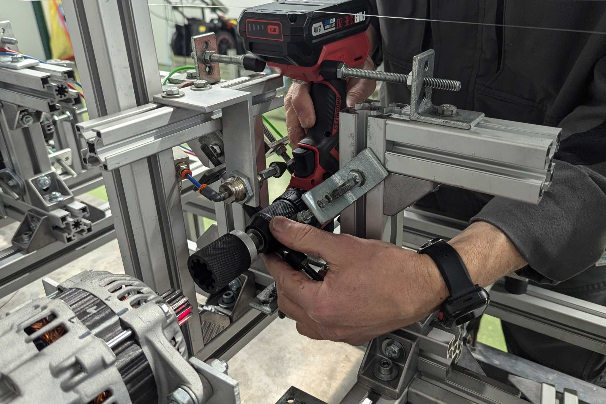 Henkilö, pora ja testauslaitteistoa laboratoriossa.