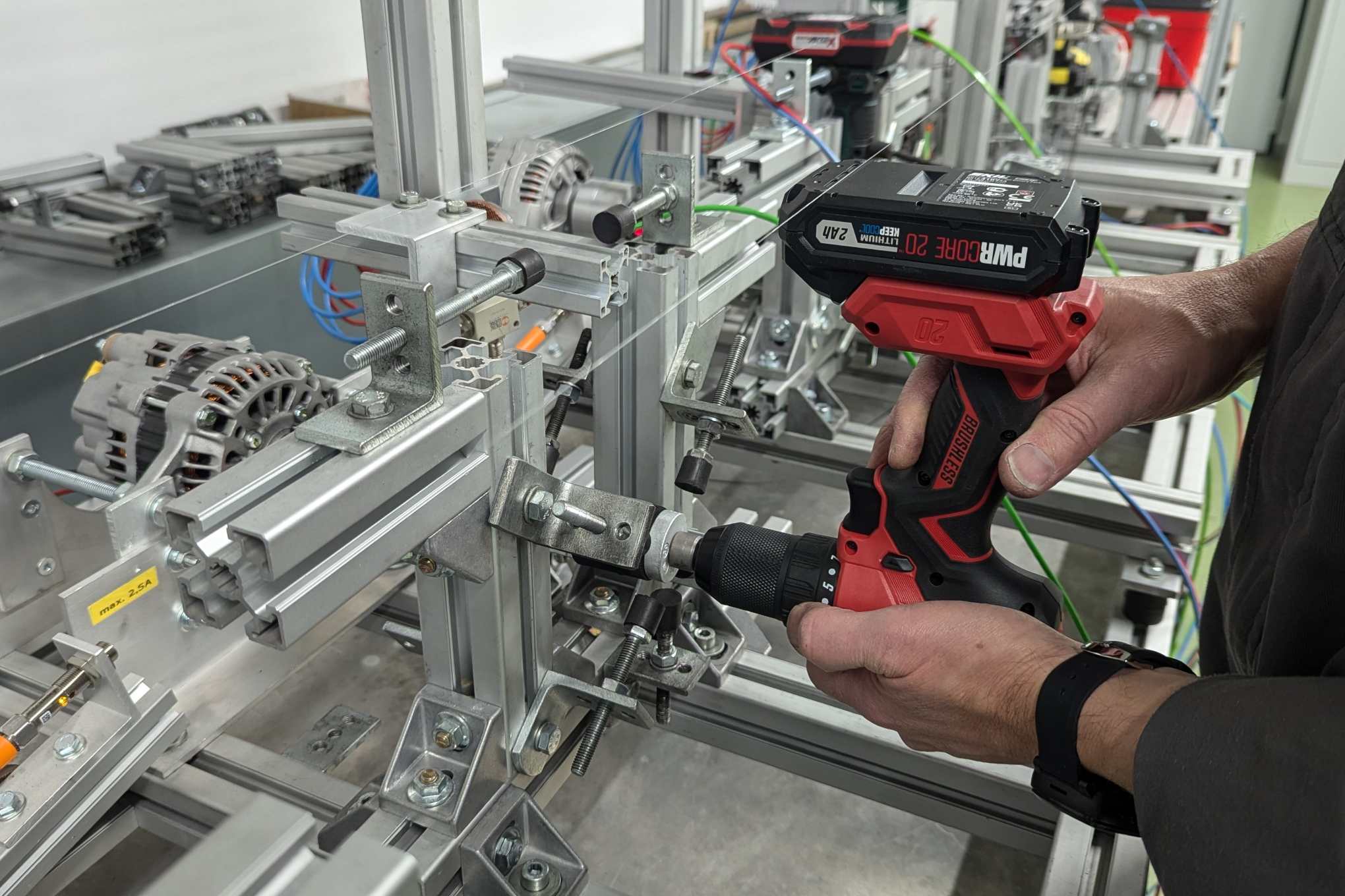 Henkilö, pora ja testauslaitteistoa laboratoriossa.