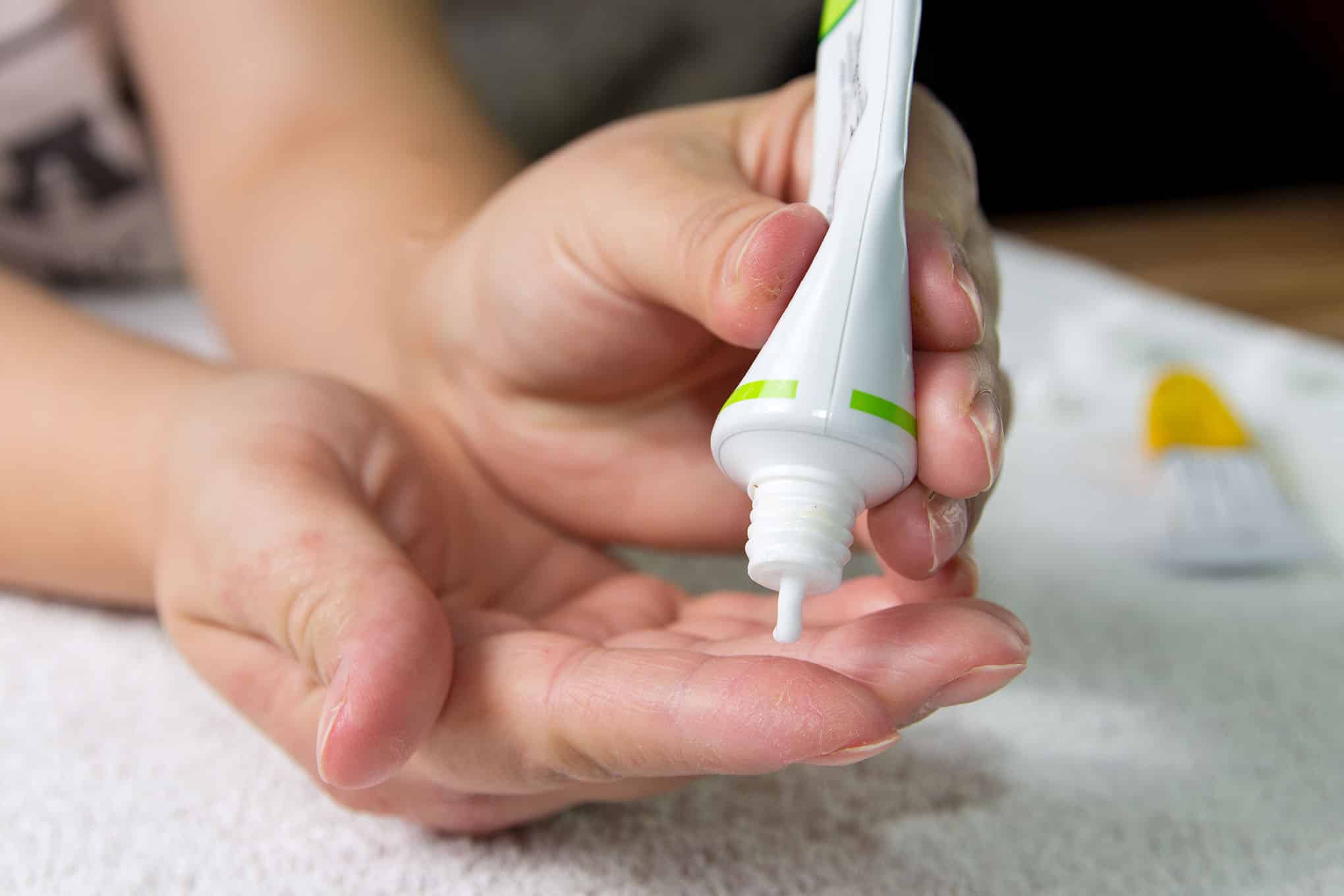 Henkilö pursottamassa voidetta käsiinsä.