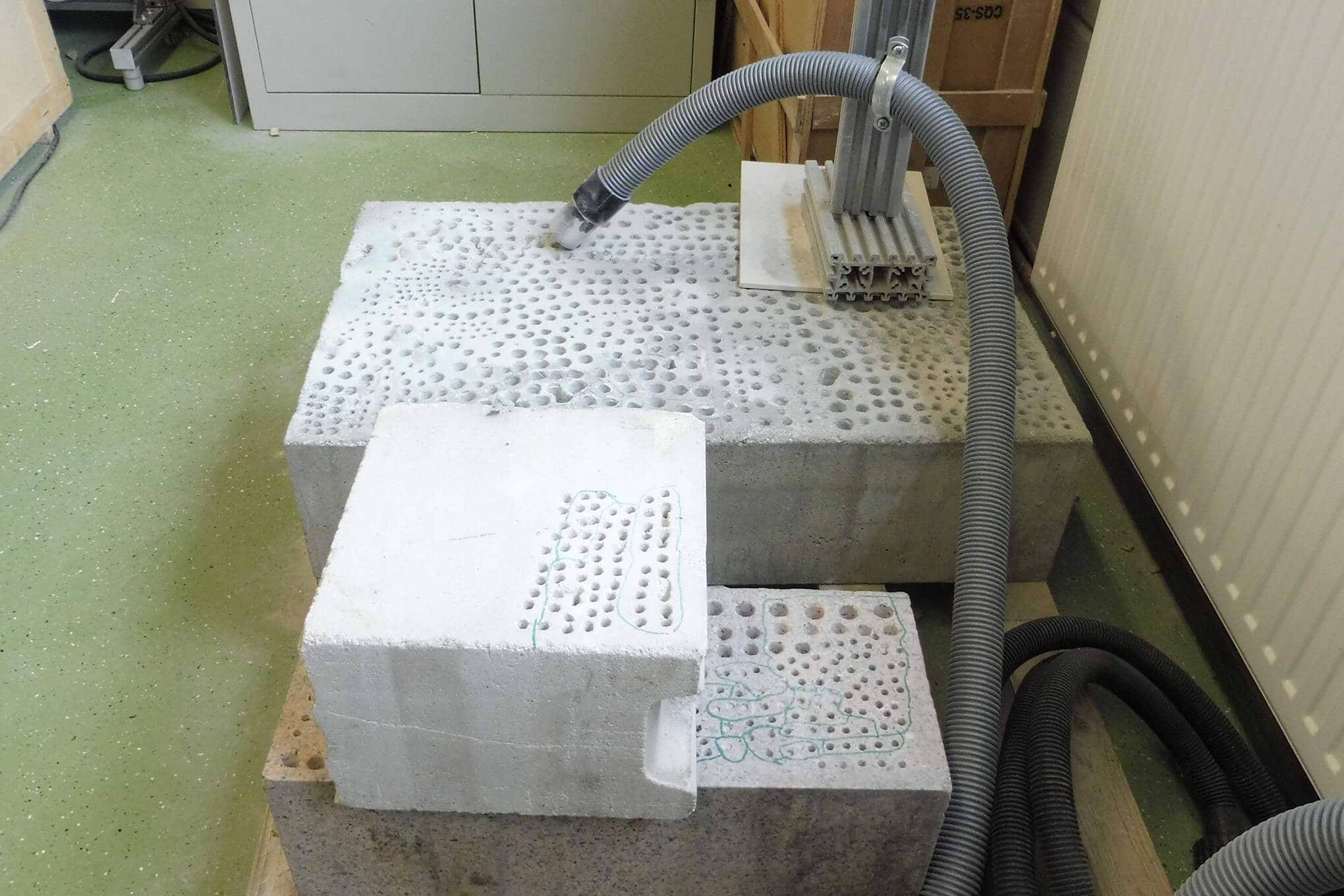 Graniitti- ja betonilohkareita sekä imuri.