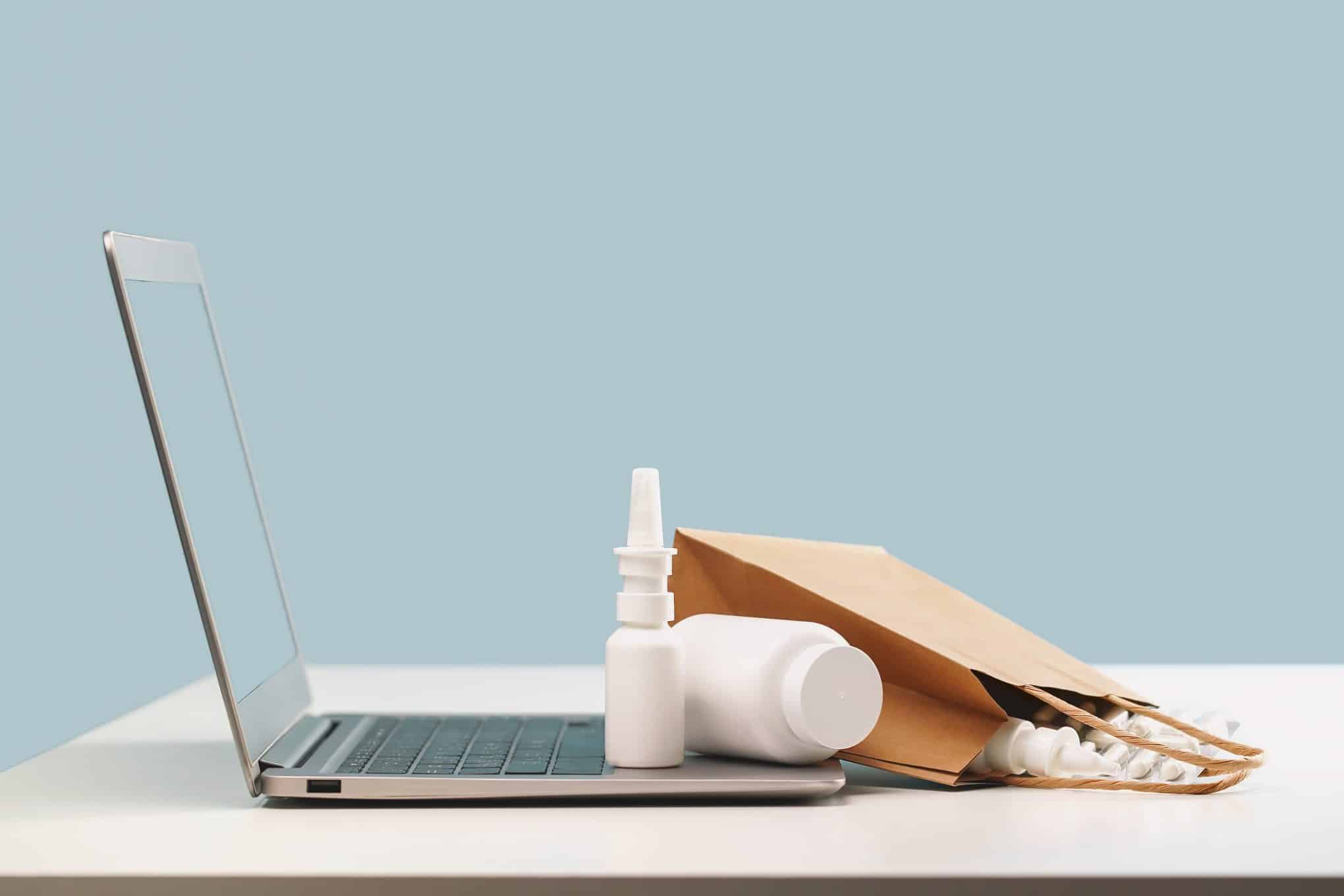 Pöydällä on tietokone ja lääkkeitä.