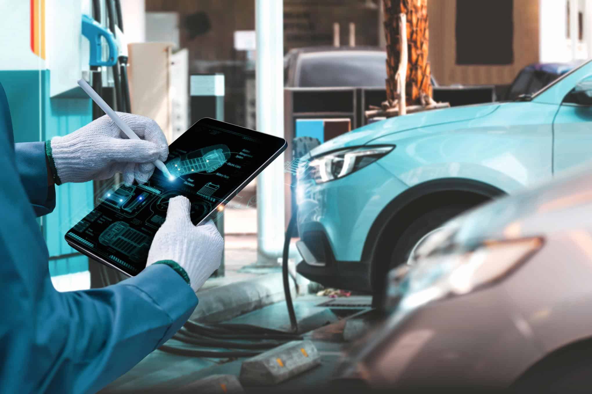 Sähköautoja, ja henkilö säätämässä auton asetuksia tabletilla.