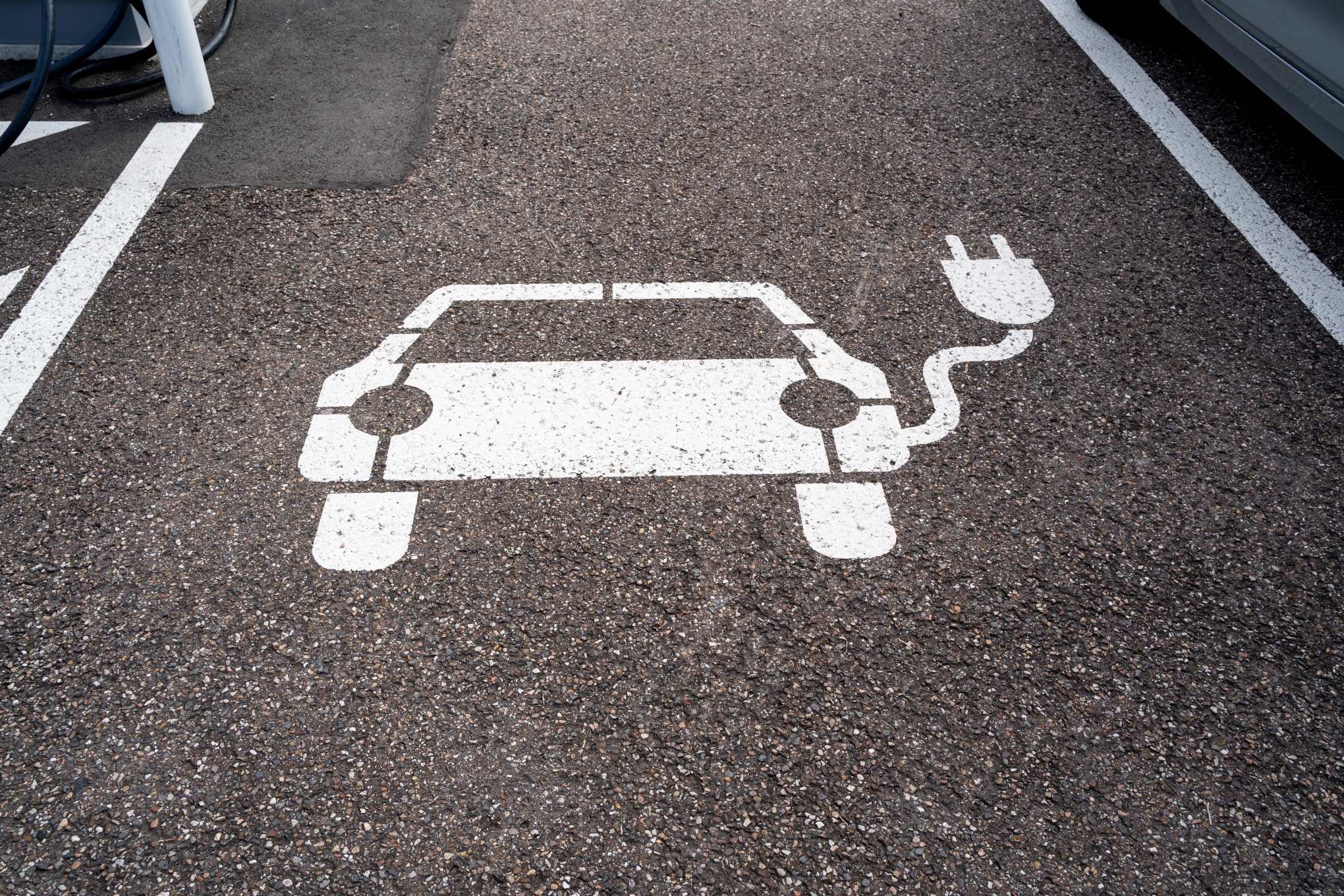 Asfalttiin maalattu sähköauton latauspaikan merkki.