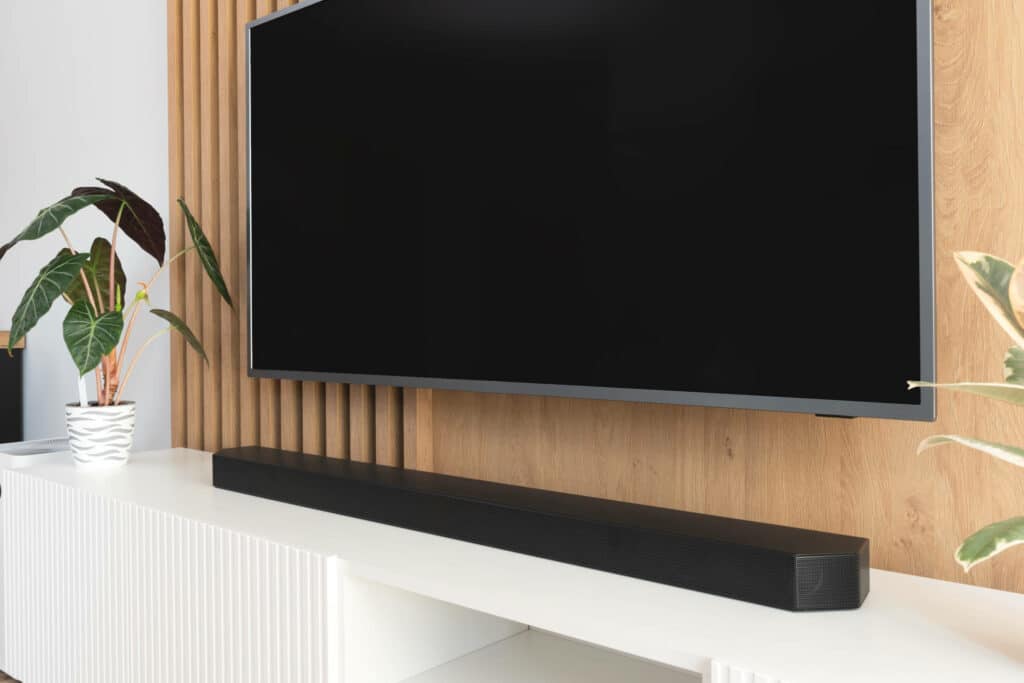 Seinällä on televisio, jonka alla on soundbar-kaiutin.