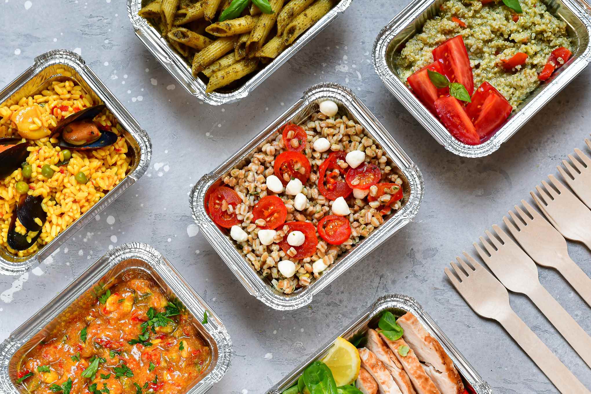 Erilaisia ruokia alumiinivuoissa.