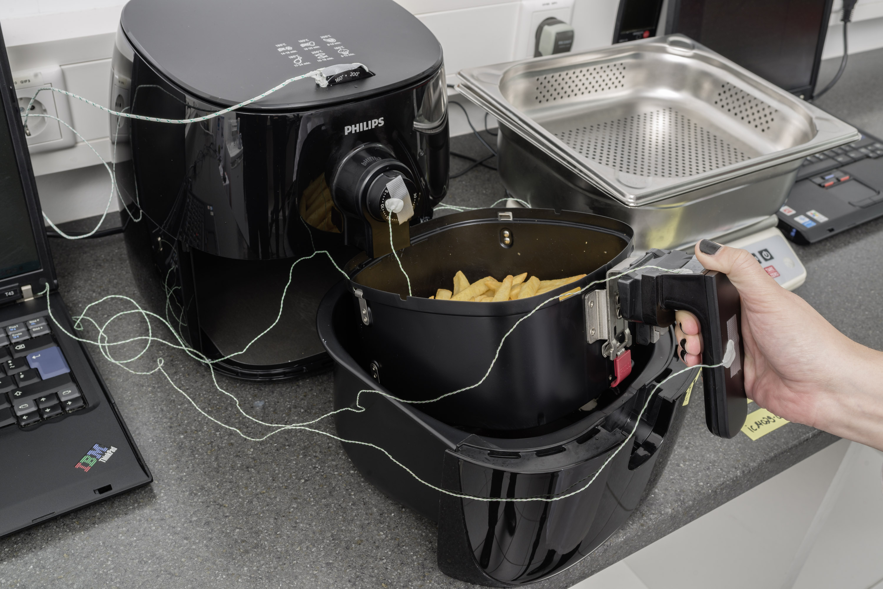 Airfryer ja testauslaitteistoa laboratoriossa.