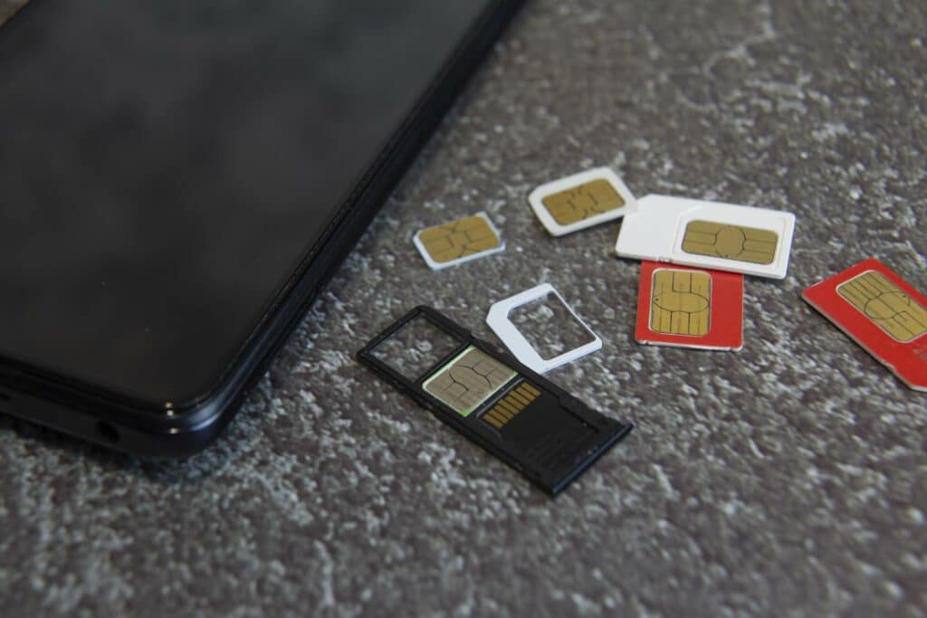 Tietokone ja puhelimien sim-kortteja.
