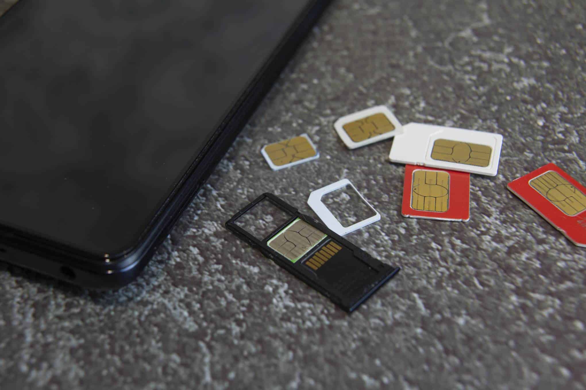 Tietokone ja puhelimien sim-kortteja.