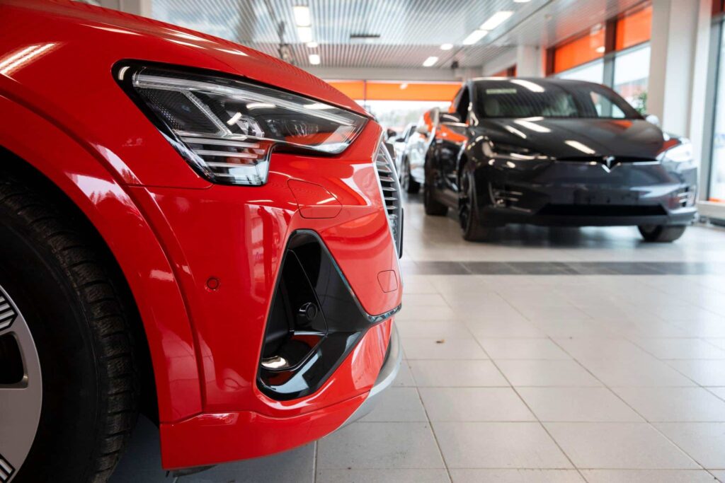 Punainen ja musta henkilöauto autokaupassa.