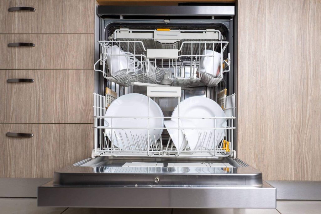 Auki oleva astianpesukone, jonka sisällä on astioita.