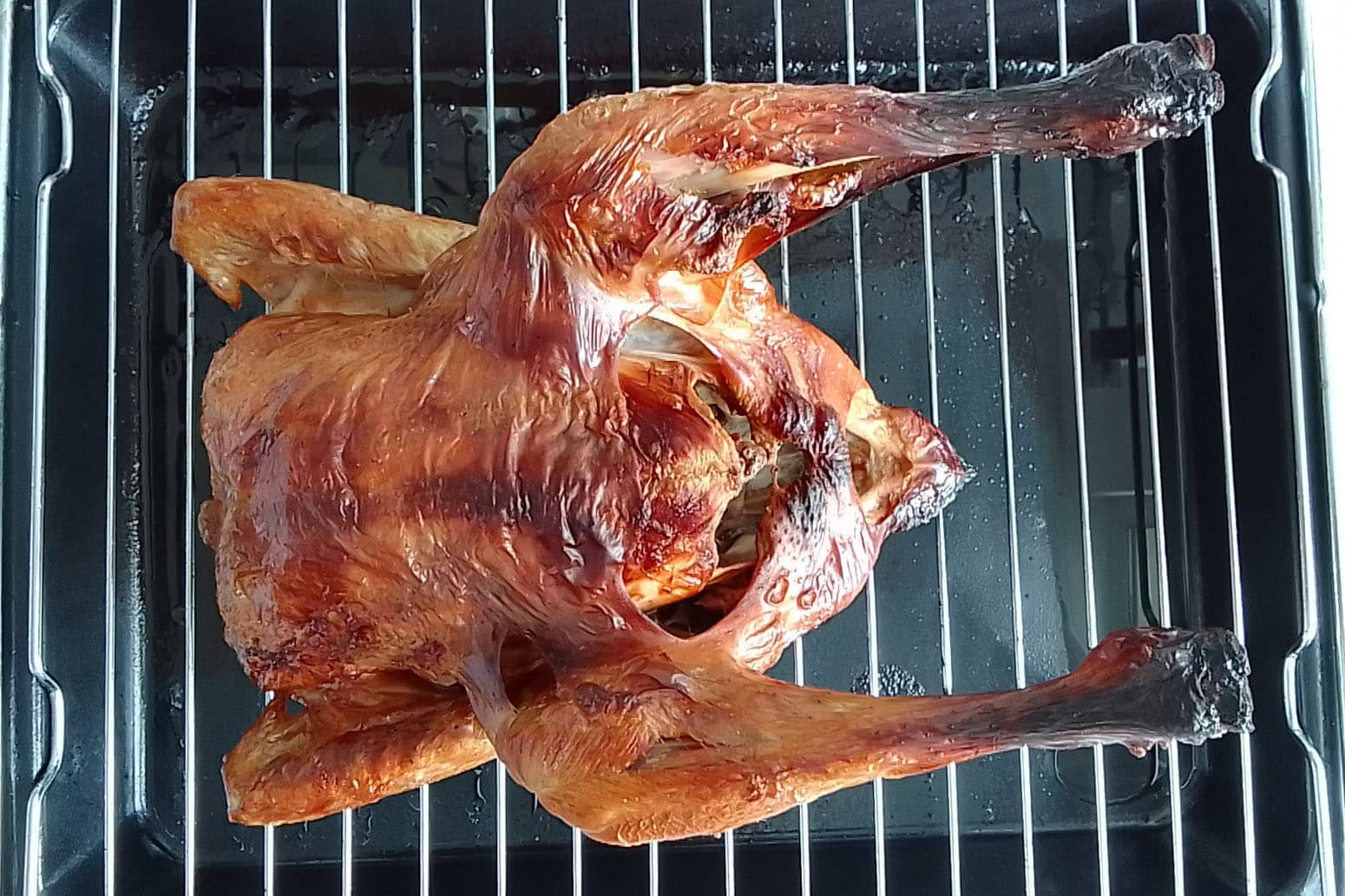 Paistoritilä, jonka päällä on kokonainen paistettu broileri.