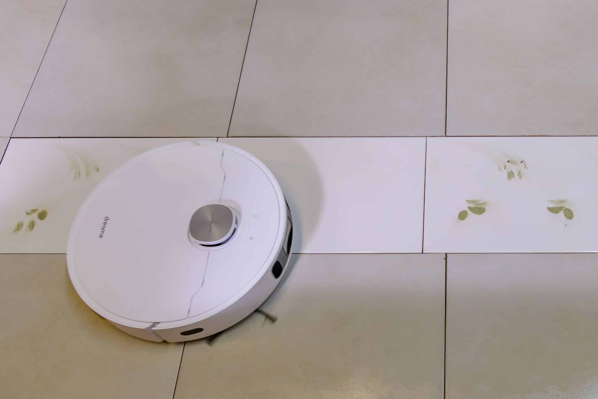 Laatta-lattialla on robotti-imuri ja likaa.