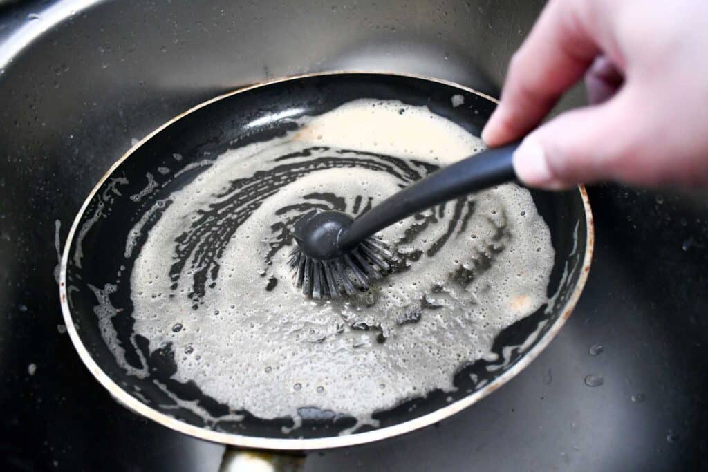 Henkilö puhdistamassa paistinpannua.