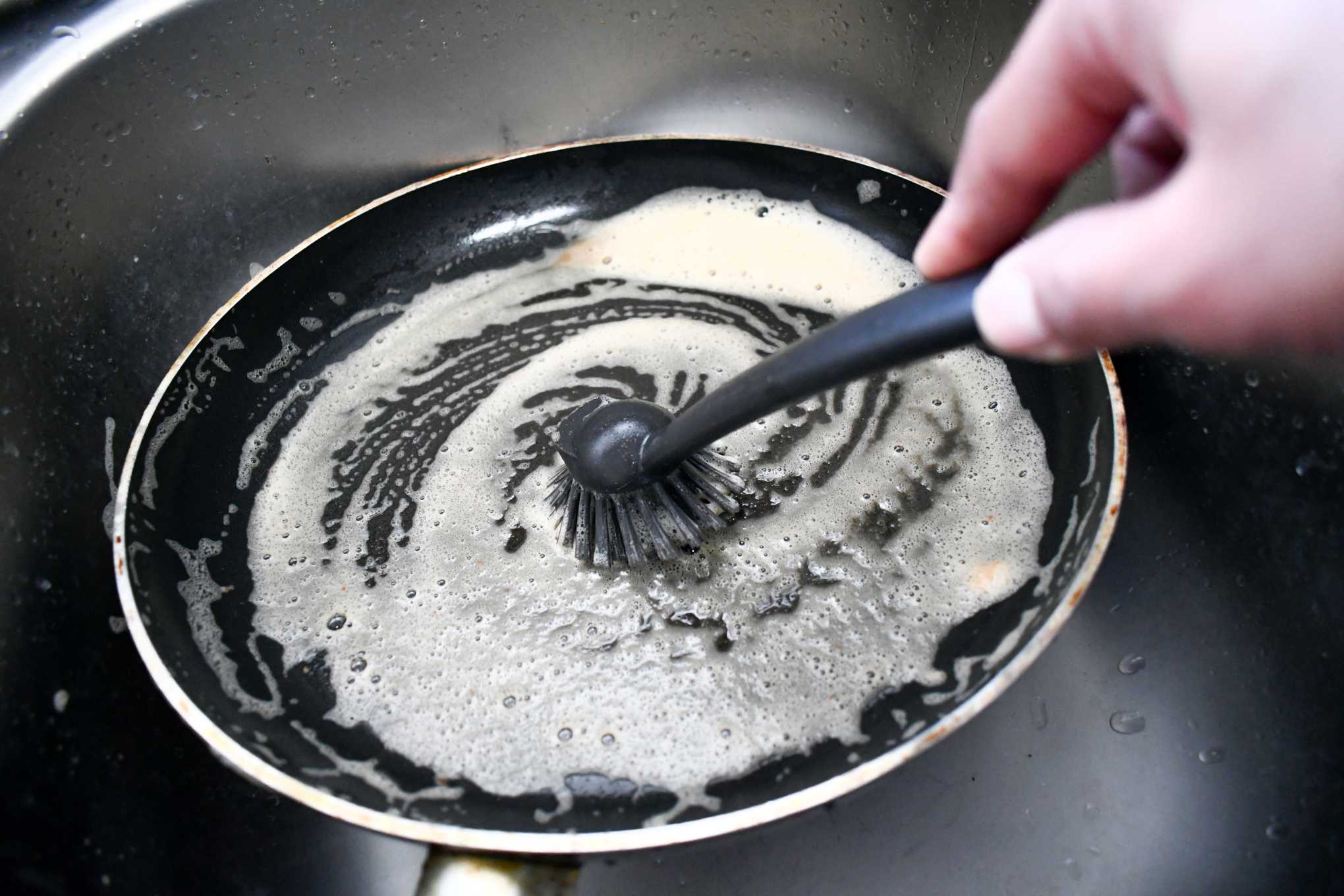 Henkilö puhdistamassa paistinpannua.