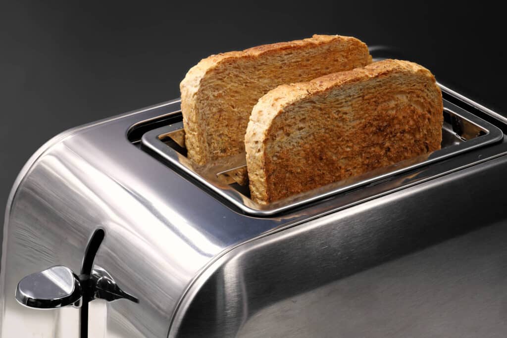Leivänpaahdin, jonka sisällä on kaksi paahtunutta paahtoleipäviipaletta.